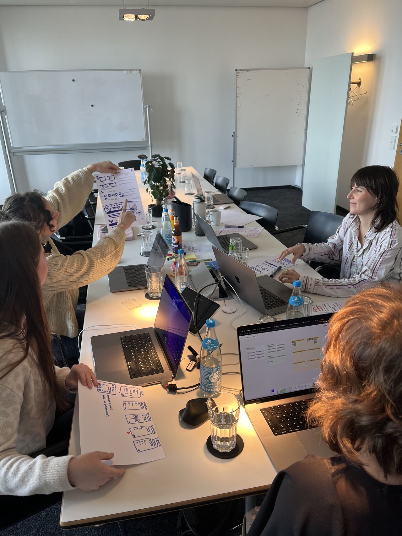 Team discussing sketches around the meeting table